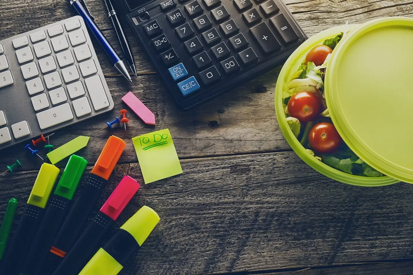 Top-down view of a business concept: office accessories and supplies on a wooden table; study/work theme; with toning.